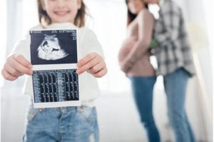 ילדה מחזיקה צילום של תינוק בבטן